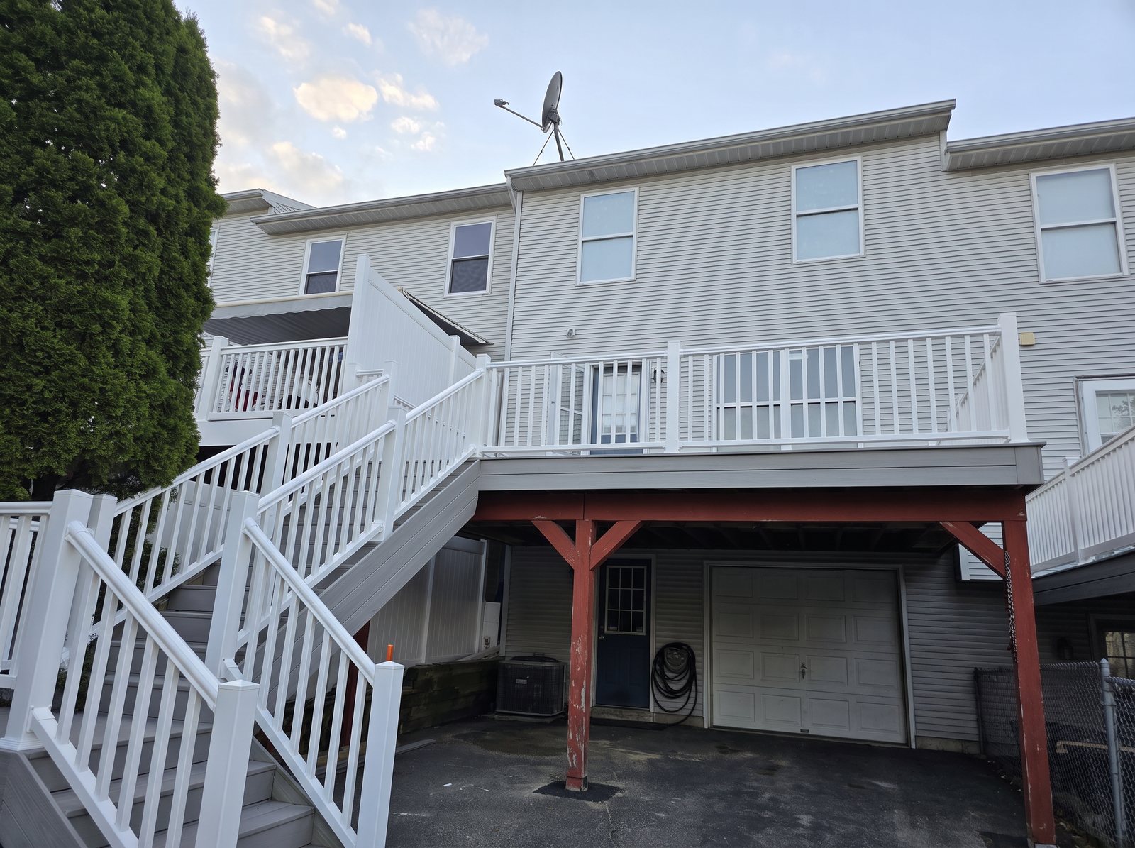 After: the same deck rebuilt with gray composite boards and white railings and stairs