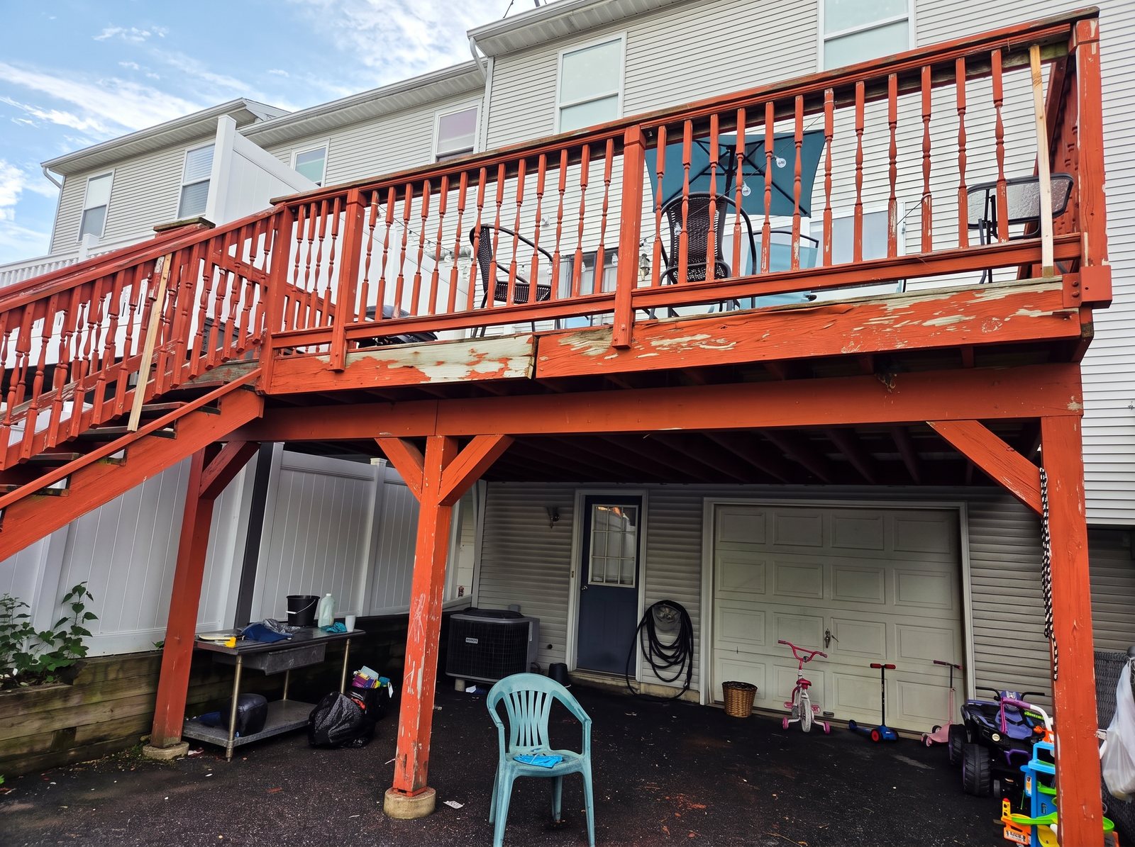 Before: worn red-stained wood deck with peeling boards