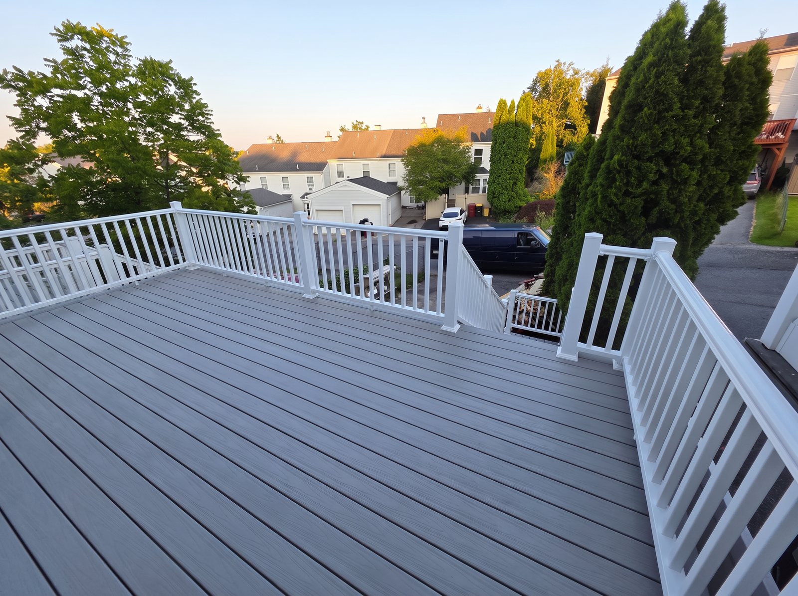 New gray composite deck with white railings at sunset