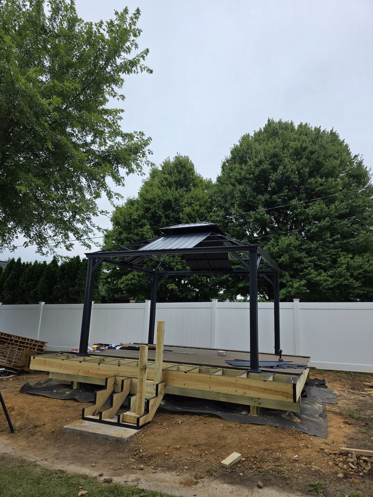 Deck frame with stair stringers and a metal gazebo going up