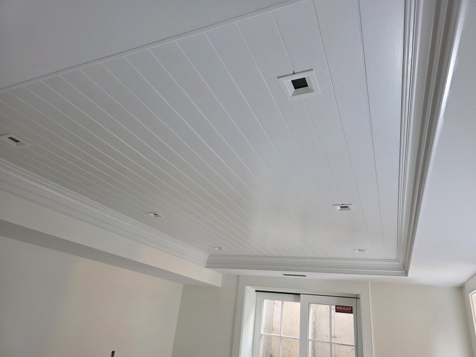 Finished white shiplap tray ceiling with crown molding